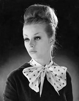 00056 Prints: Reveille Fashions. Mannequinn modeling a scarf tied into a bow. January 1964 P007553