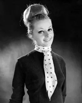 Hair Styles Prints: Reveille Fashions. Mannequinn modeling a scarf tied with a tie knot. January 1964 P007616
