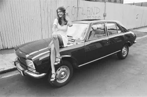 Reveille model Beulah Hughes seen here posing with a Peugeot 504 car which is a top prize