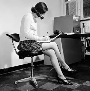 Reveille Studio Model posing as a secretary with a garter watch strapped to her thigh