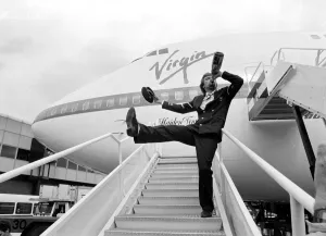 Airlines Prints: Richard Branson drinking from a bottle of champagne as he celebrates Virgin Atlantic