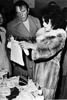 Richard Burton actor and Elizabeth Taylor who recently remarried buying a baby suit