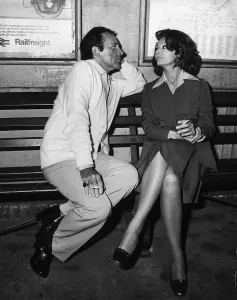 Richard Burton with Sophia Loren on a bench at a train station filming the play brief