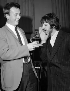 Ringo Starr sings into a toy gramaphone after sound engineer Geoff Emerick won a Grammy