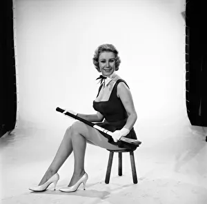 Rita Royce modelling sports kit with hockey stick. Circa 1959
