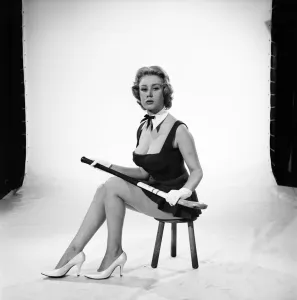 Rita Royce modelling sports kit with hockey stick. Circa 1959