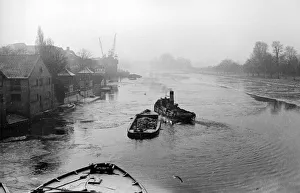 The river tug Thames makes its way through the frozen river Thames at Teddington