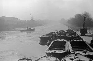 The river tug Thames makes its way through the frozen river Thames at Teddington