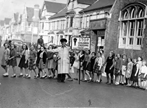 Road Safety Prints: Road Safety - Lollipop Men / Women - A lollipop man showing children across the road in
