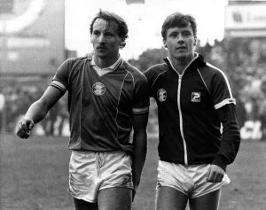 Robert Hopkins (left) is led off the pitch after being injured by West Ham fans when they