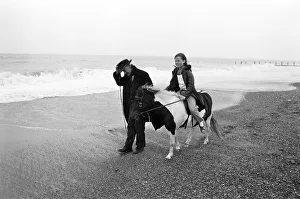 Robert Jackson pony ride owner takes Elizabeth Hood for a ride along a blustery beach