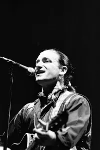 Rock group U2 in concert in USA. Bono singing and playing guitar. May 1987