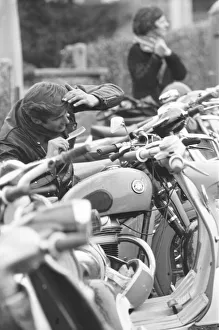 Rocker combs his hair using the mirror of a mods scooter on Clacton sea front