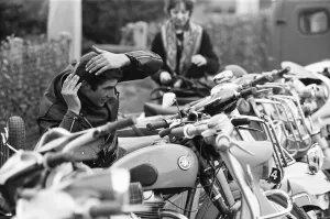 Rocker combs his hair using the mirror of a mods scooter on Clacton sea front