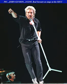 Rod Stewart dancing with the mike on stage at the SECC in Glasgow pointing