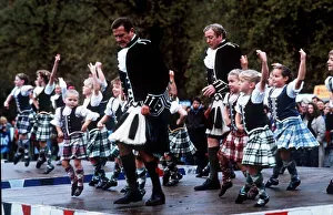 Kilts Prints: Roger Moore with Michael Caine dancing with children November 1989