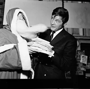 Roger Moore pictured with Santa at Pontings Department Store, Kensington, London