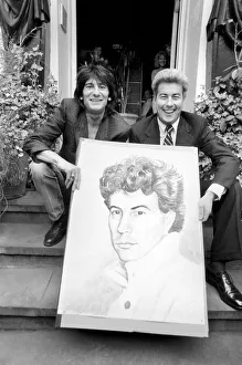 Artwork Prints: Rolling Stones: Ronnie Wood holds a painting of author Ken Follett who stands next to him
