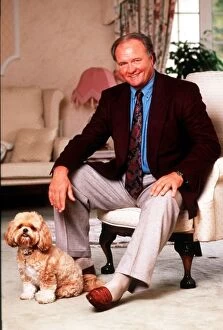 Images Dated 13th January 1991: Ron Atkinson Football manager sitting on chair at home with his pet dog. January 1991