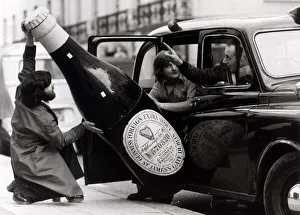 Taxis Prints: Ron Nicholson (left) Bill Barnard trying to get a large bottle of Guinness into a London