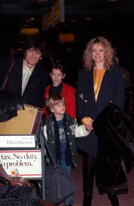 00006 Prints: Ronnie Wood and family arriving at Heathrow airport in February 1990