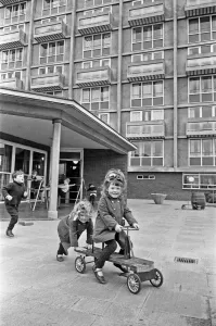 Nursery Prints: Rose Anne Kelly rides the trike with her sister Christina pushing during break time
