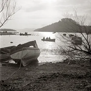 Landscapes And Gardens Prints: Rowing boats on scenic lake Row boat moored ashore by lakeside Wooded hill in