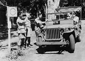 00074 Prints: Royal Air force squadron leader driving his jeep is halted for alift at an RAF Airfield