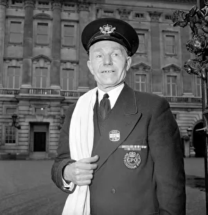 Gates Prints: The Royal Postman stands at the gates to Buckingham Palace before collecting Queen