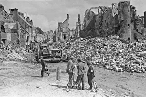 Ruined buildings and wrecked German transport in the streets of Montebourg as a result of
