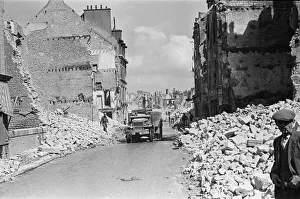 Ruined buildings and wrecked German transport in the streets of Montebourg as a result of