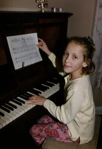 Ruth Walton one of the Walton Sextuplets sits at a piano to play dbase