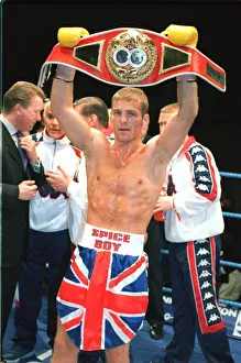 Ryan Rhodes Boxer standing in the ring holding belt celebrates after winning the IBF