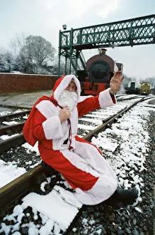 Santa stopped in his tracks. Father Christmas sitting on railway tracks