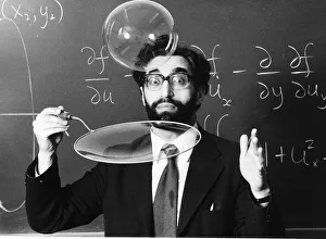 One Mid Adult Man Only Prints: Science lecturer Cyril Isenberg blowing large bubbles March 1980 1980s