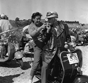 Scooters Prints: Scooter rally 1958 woman lighting cigarette for man A young woman lights