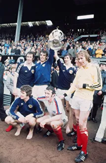 Scotland footballer Joe Jordan holds aloft the British International Football trophy with