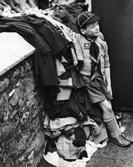 00003 Prints: Scouts Peter Roberts aged 8 guards a pile of coats as his pack take part in a carnival