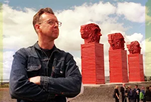 Sculptor David Mach June 1999 beside his Big Heids sculpture alongside the A8