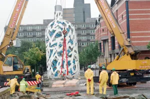 The sculpture Bottle of Notes is lifted off its low loader in the Central