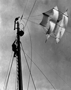 Ladders Prints: A seaman up the main mast adjusting the huge kite that carries a slender cable