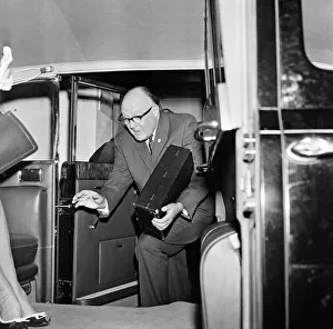 Secretary of the Football Association Denis Follows carries the Jules Rimet trophy inside
