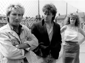 Anyone seen Elton? Puzzled... Rod Stewart and Paul Young with their bodyguard