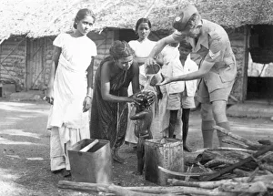 00075 Prints: Sergeant Ferris of the Royal Air Force helping to wash the hair of a young child during