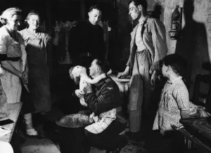 Bathing Prints: Sergeant Ted Okey helps a French woman bathe her child whilst Tommy Dalby talks to