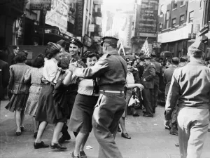 Servicemen and women dancing in the streets of London on VJ Day after Japan surrendered