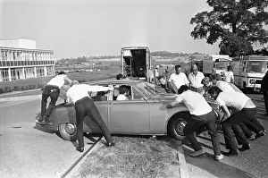 Film Production Prints: Set dressers move a Jaguar Mark II car for the next shot during location filming of