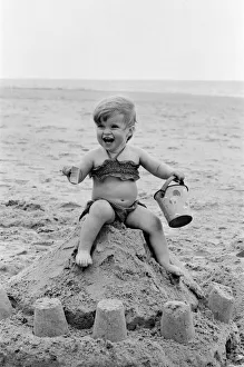 Toddler Prints: Seventeen month old Sarah Jukes from Wimbledon plays in the sand during a day