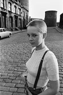 Seventeen year old skinhead teenager Janet Askham poses in the street at her home in