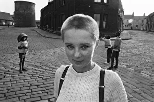 Seventeen year old skinhead teenager Janet Askham poses in the street at her home in